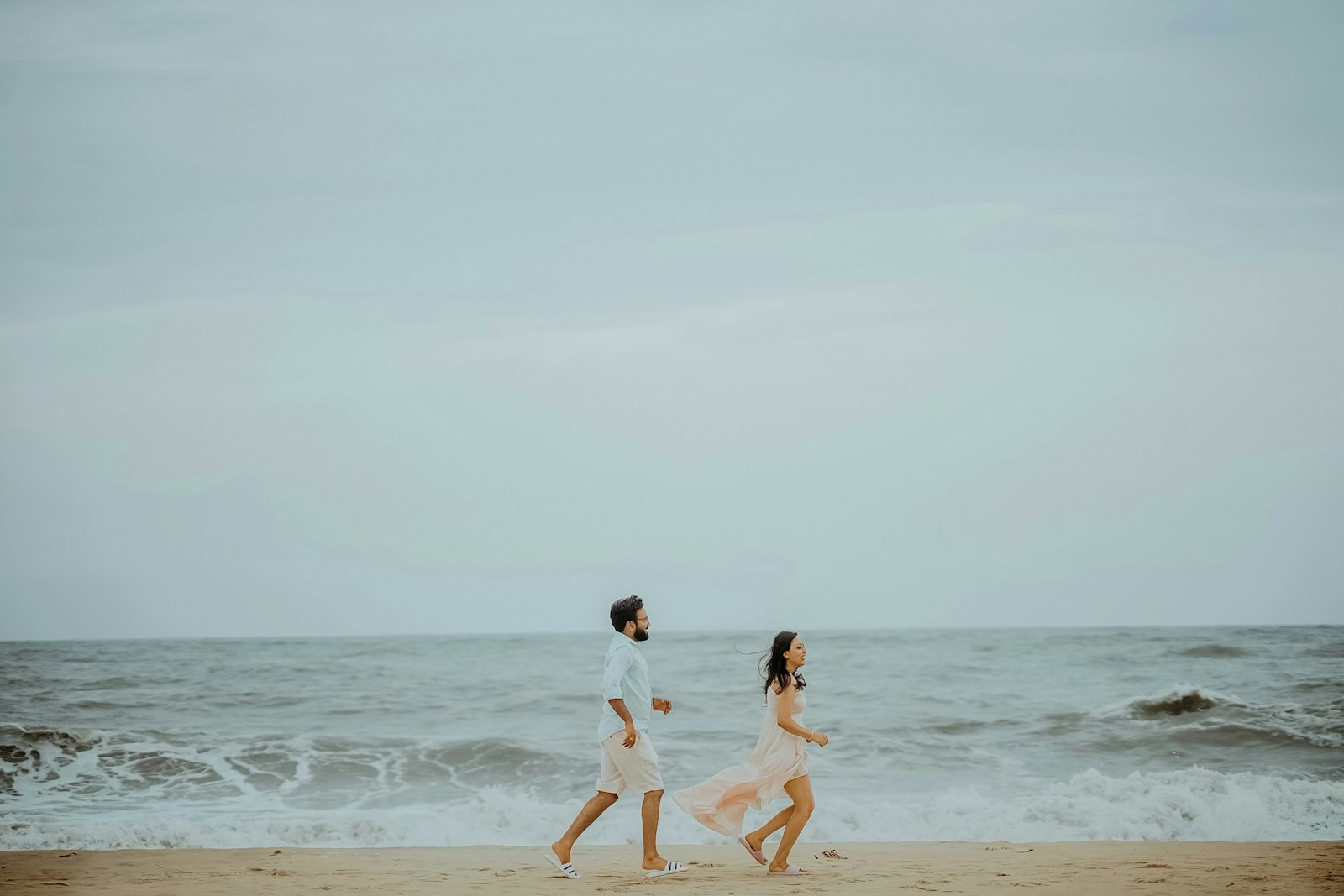 Couple running along the shore
