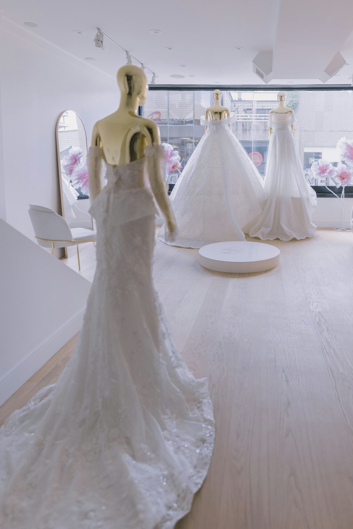 Wedding gowns on mannequins in a bright fitting room