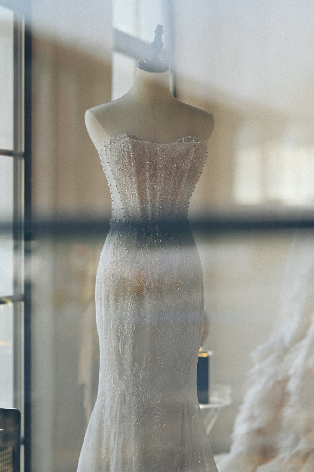 Strapless gown on a mannequin by a window