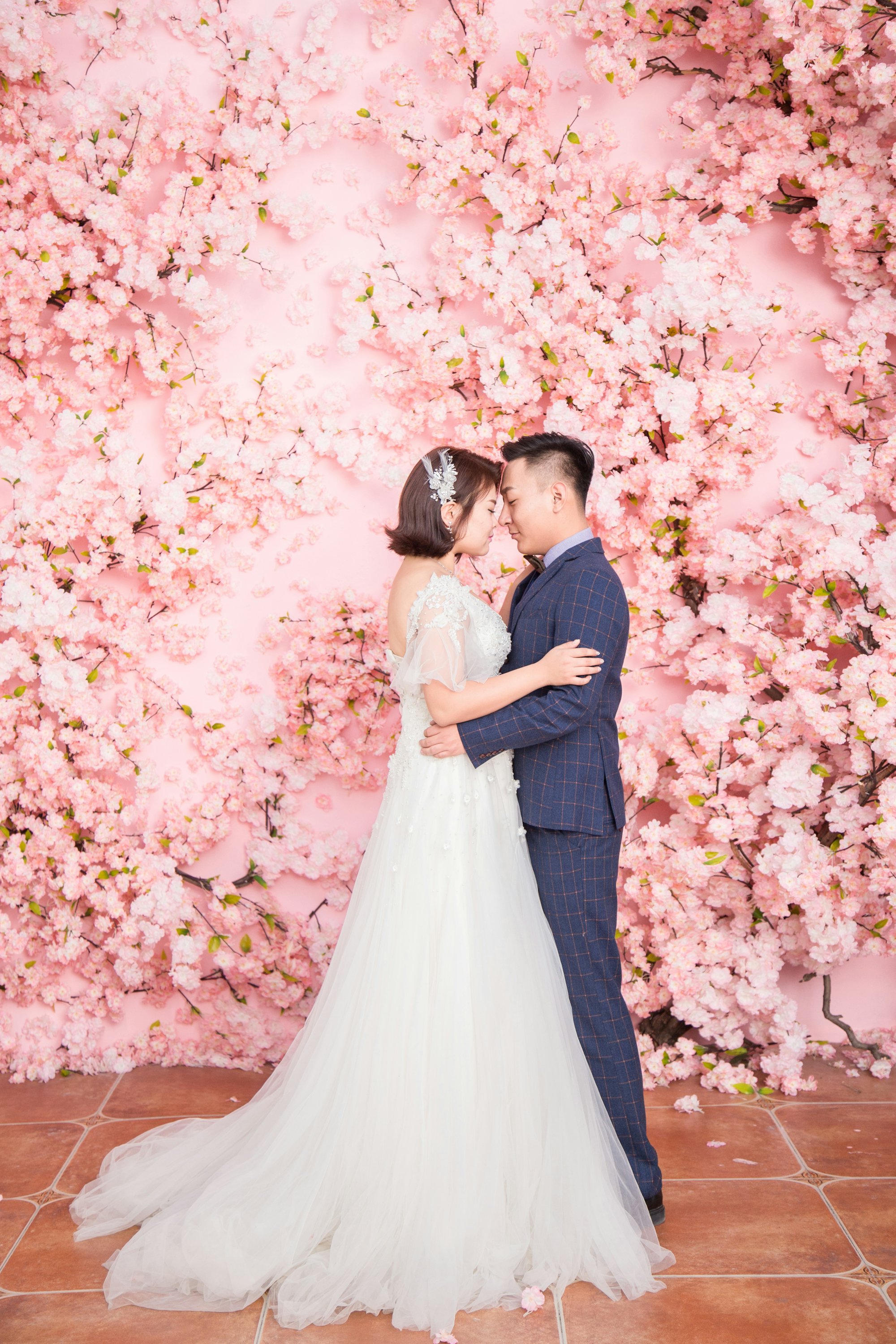 Couple in front of a pink blossom wall